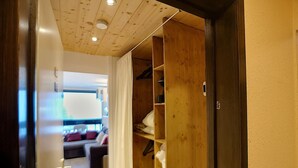 Un pasillo que conduce a un dormitorio con un armario de madera, un sofá y una cama.