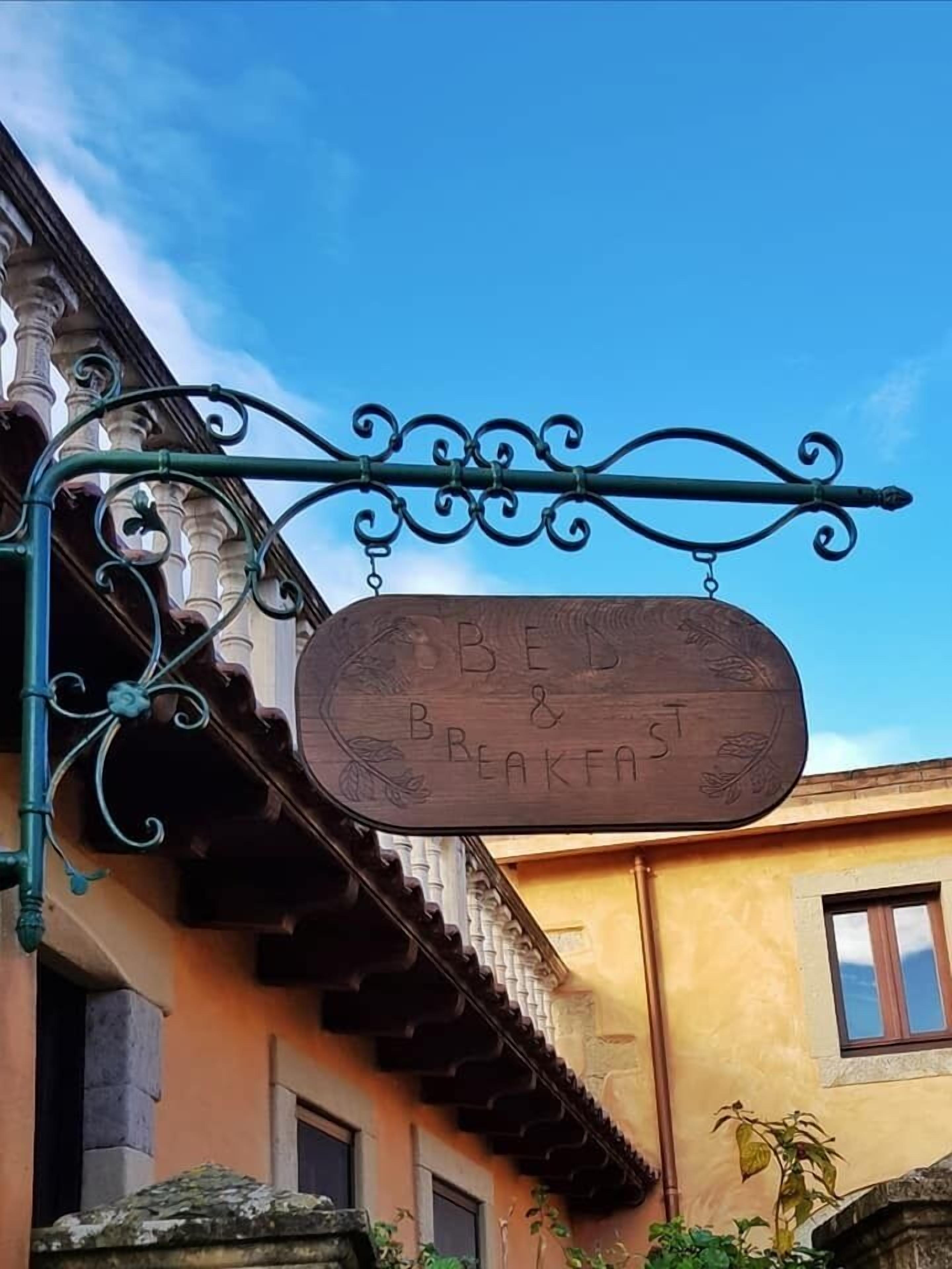 Ein Schild für ein Bed and Breakfast mit einem schmiedeeisernen Wegweiser.