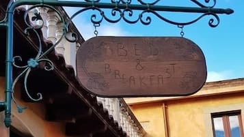 Ein Schild für ein Bed and Breakfast mit einem schmiedeeisernen Wegweiser.