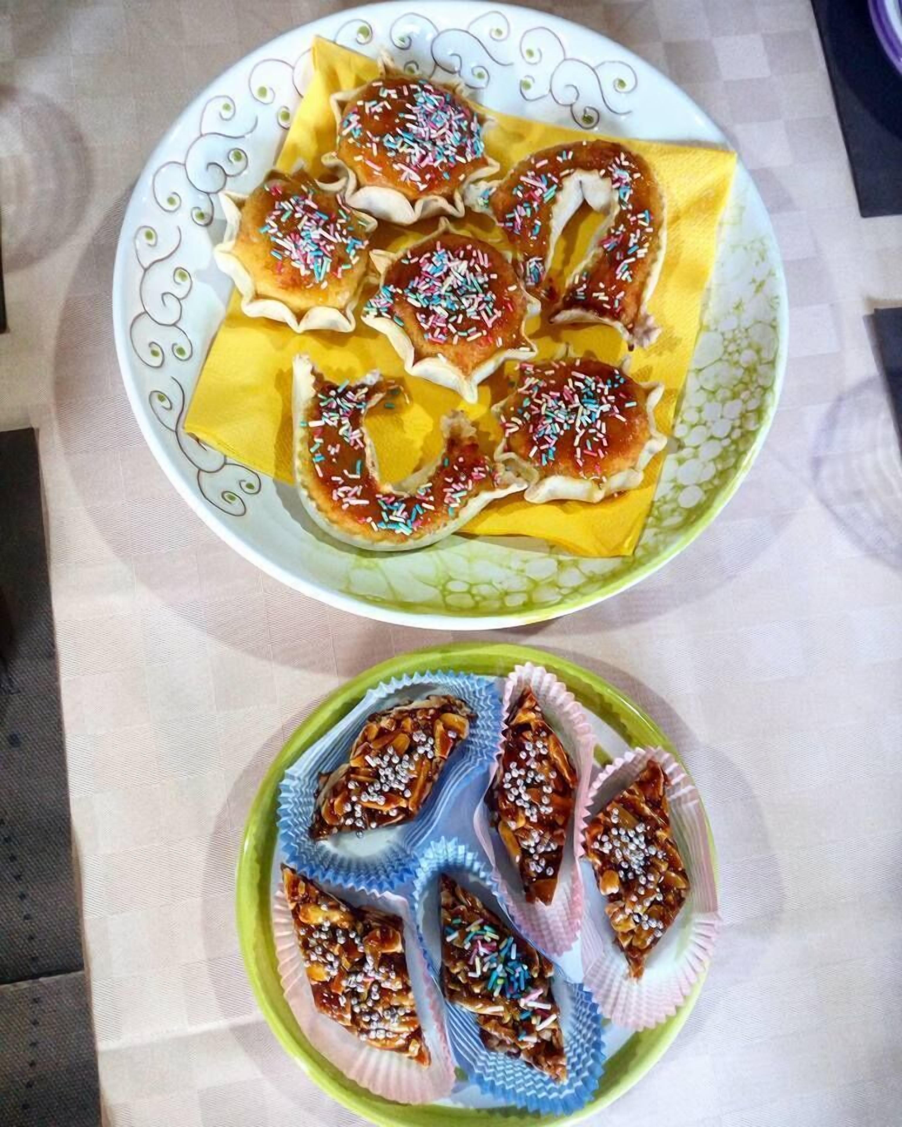Two plates of decorated pastries on a table.