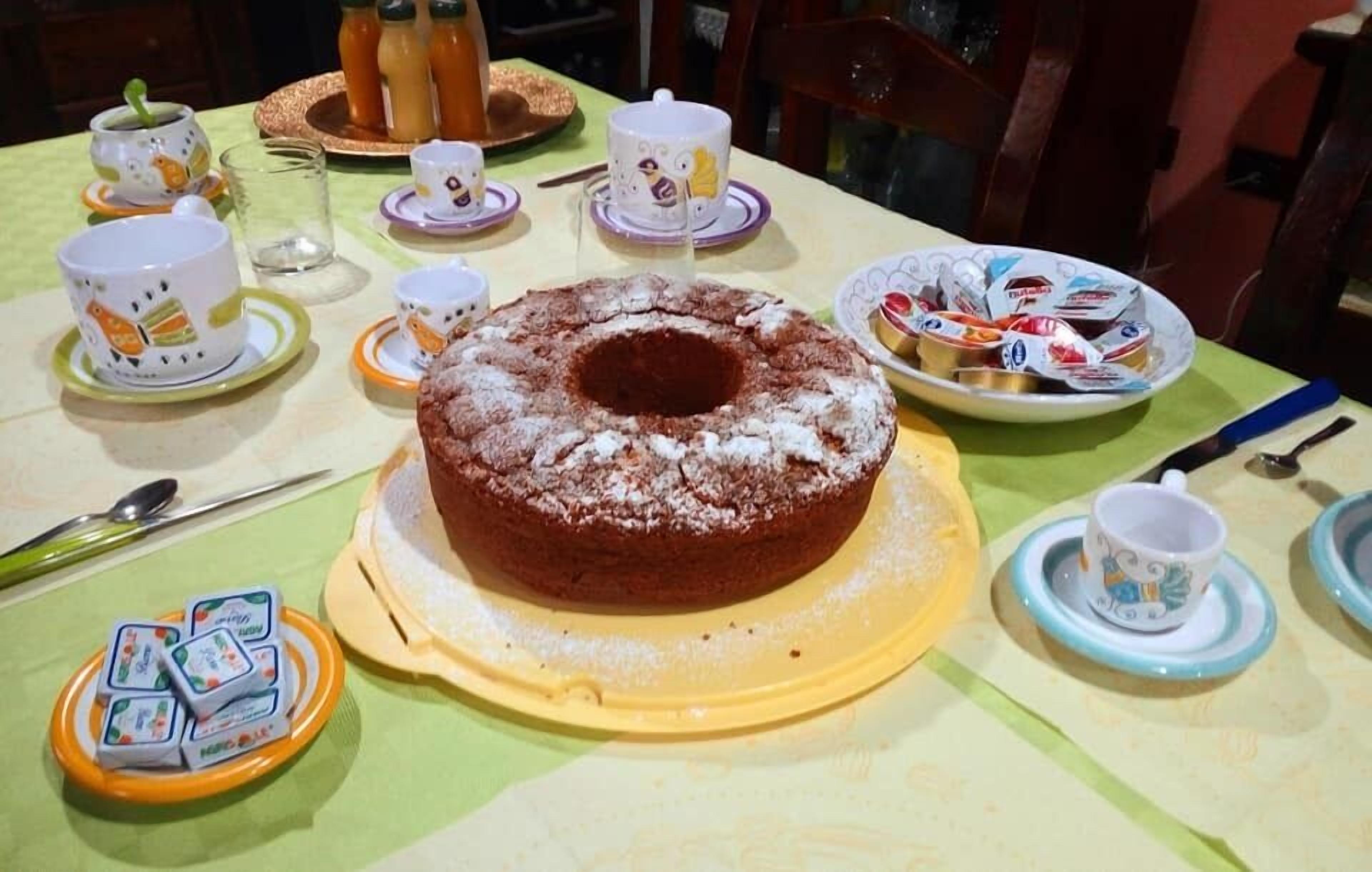 A table set with a bundt cake, teacups, and plates.