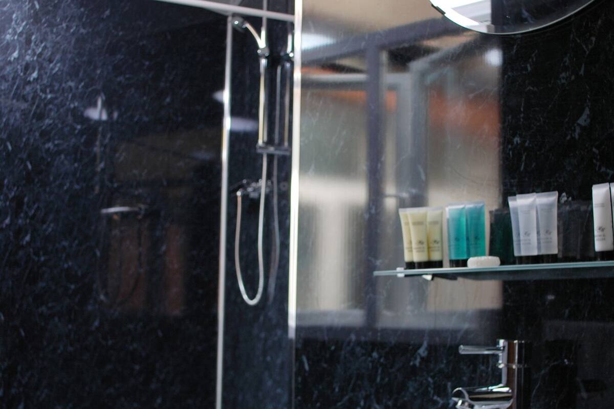 A modern bathroom with a white toilet, a white sink, and a glass shower enclosure.