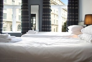 A hotel room with two beds, a large window, and a view of a historic building. - The Liverpool Inn Hotel (Liverpool)