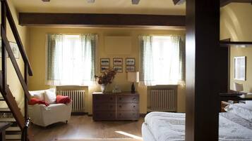 A bedroom with a bed, a dresser, a chair, and a radiator.