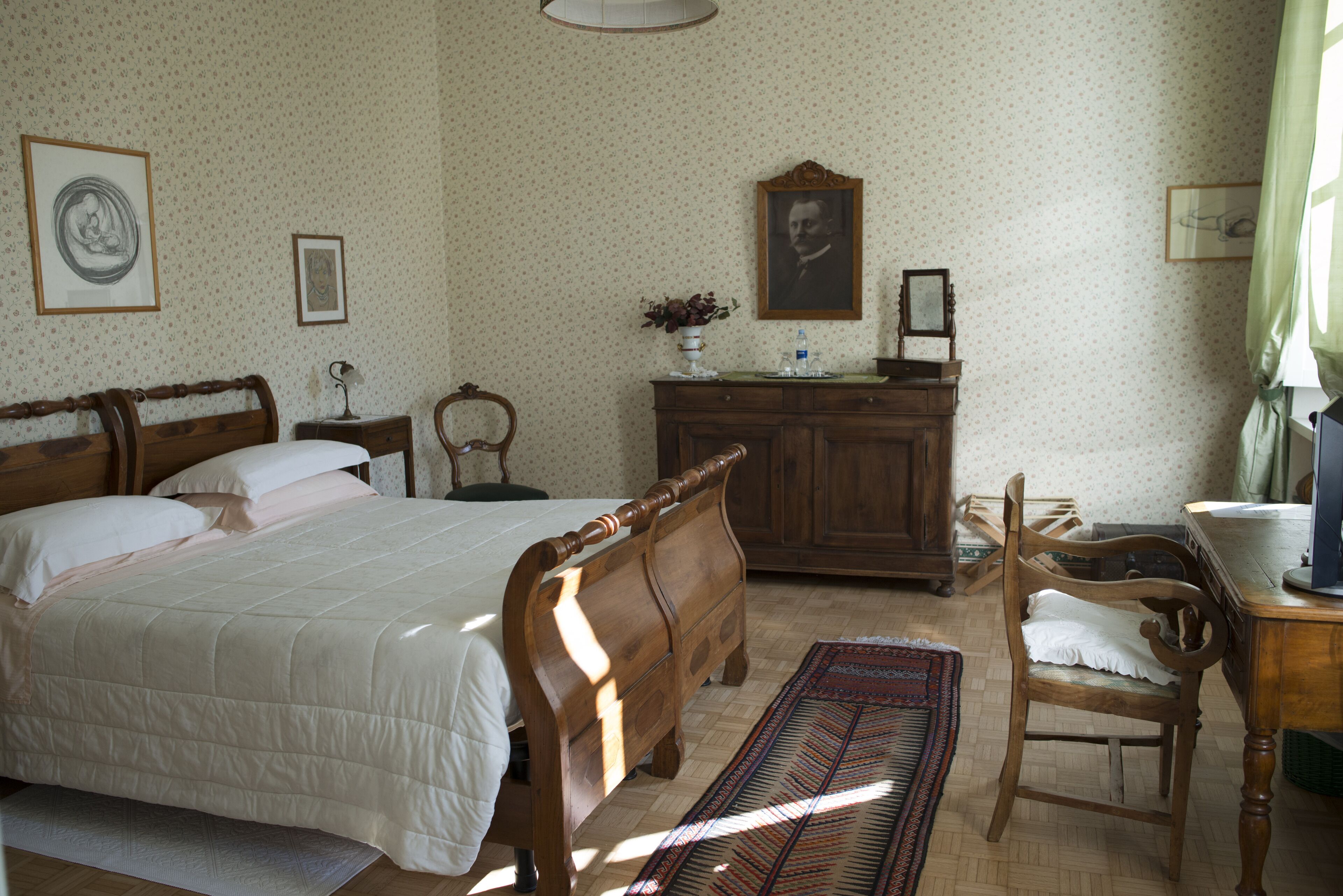 A bedroom with a wooden bed, a dresser, a chair, and a desk.