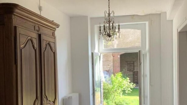 A spacious hallway with wooden flooring, a grand staircase, and a chandelier. - Grand Corps de Ferme (Branches)