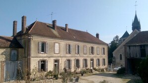 A two-story building with multiple windows and a chimney. - Grand Corps de Ferme (Branches)