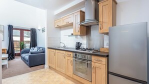 Eine moderne Küche mit Holzausstattung, einer Edelstahl-Dunstabzugshaube und einem eingebauten Backofen.