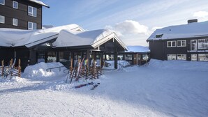 A snow-covered building with ski equipment in front. - Skeikampen Servicesenter (Gausdal)