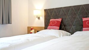 A hotel room with a bed, a nightstand with a lamp, and a wall-mounted light fixture. - Chalet in Mayrhofen Near Ski Lifts (Schwendau)