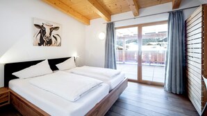 Una cama doble con ropa blanca, un cabecero de madera y un cuadro de una vaca en la pared.