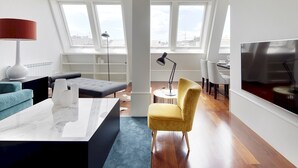 A modern living room with a marble coffee table, a yellow armchair, and a TV on the wall. - Playa de La Concha 7 by FeelFree Rentals (Donostia)