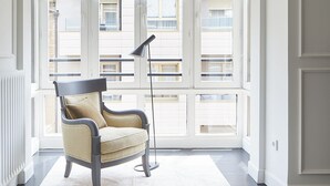 A spacious room with large windows, a single armchair, and a floor lamp. - Pitipombo by FeelFree Rentals (Donostia)
