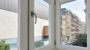 A view through a window of a building with a tiled facade and a balcony. - Concha Bay 3 by FeelFree Rentals (Donostia)