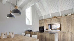 A modern kitchen with a wooden island, pendant lighting, and a "welcome home" sign. - Era Cuma by FeelFree Rentals (Pujo)