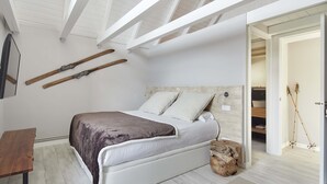 A bedroom with a bed, a wooden bench, and a mirror. - Era Cuma by FeelFree Rentals (Pujo)