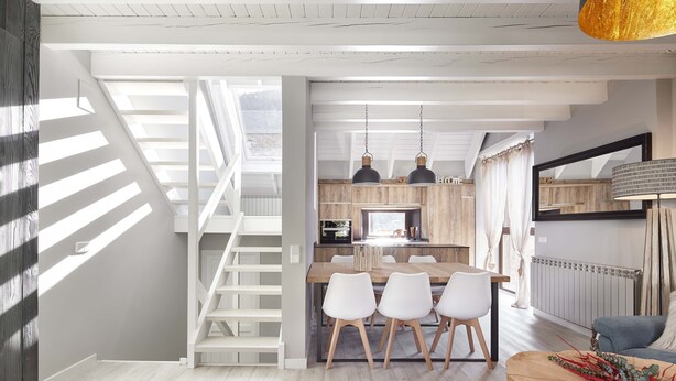 A modern kitchen with a dining area, white furniture, and a staircase leading to an upper level. - Era Cuma by FeelFree Rentals (Pujo)