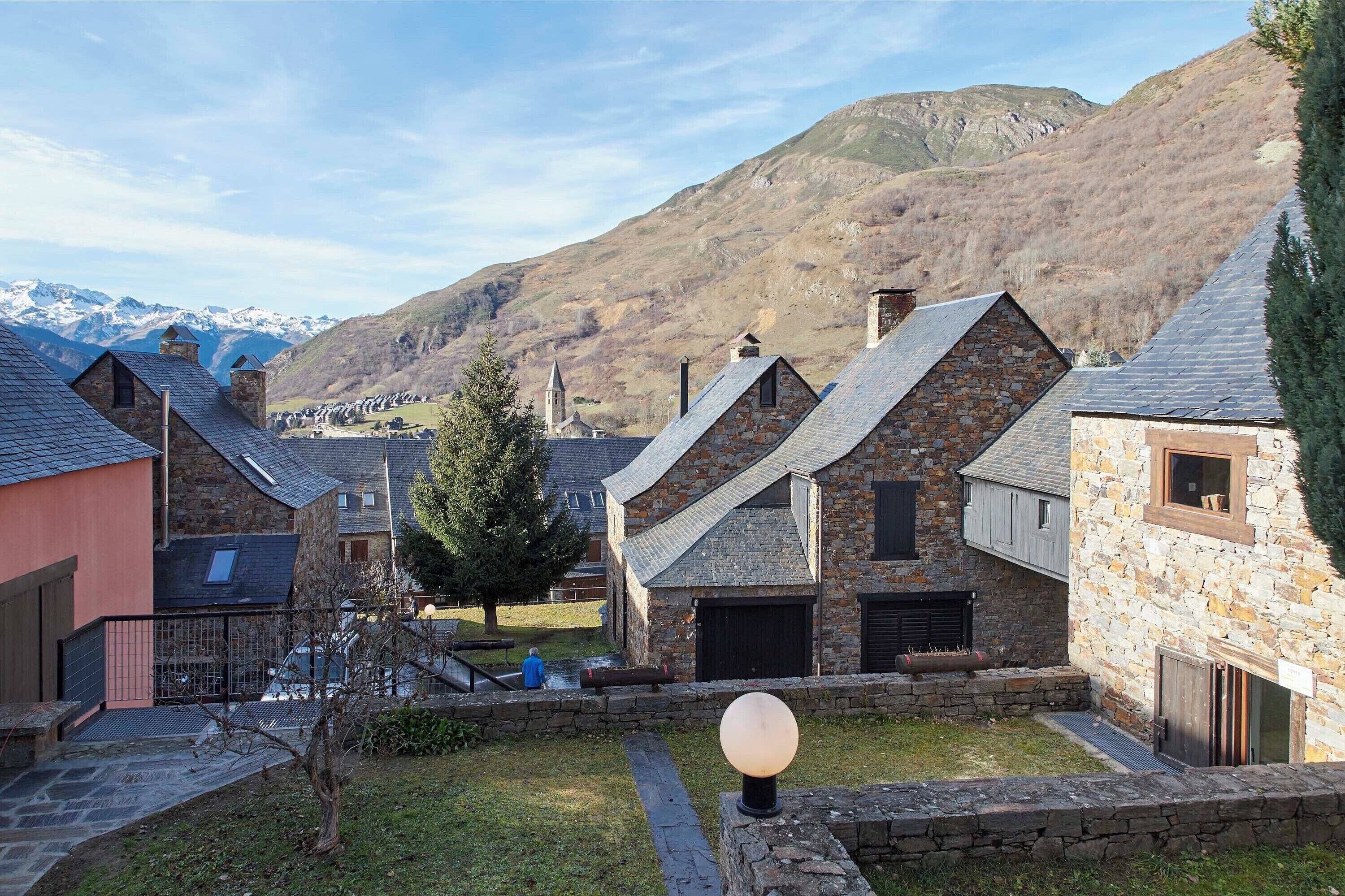 A stone building with a sloped roof, a small window, and a door.