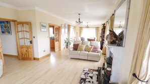 Una sala de estar amplia con un sofá, chimenea y comedor.