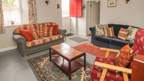 A living room with two sofas, a coffee table, and a patterned rug. - Limestone Cottage (Carran)