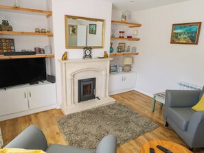 A living room with a fireplace, television, sofa, and a coffee table. - 2 Castle Cove (Dromahair)