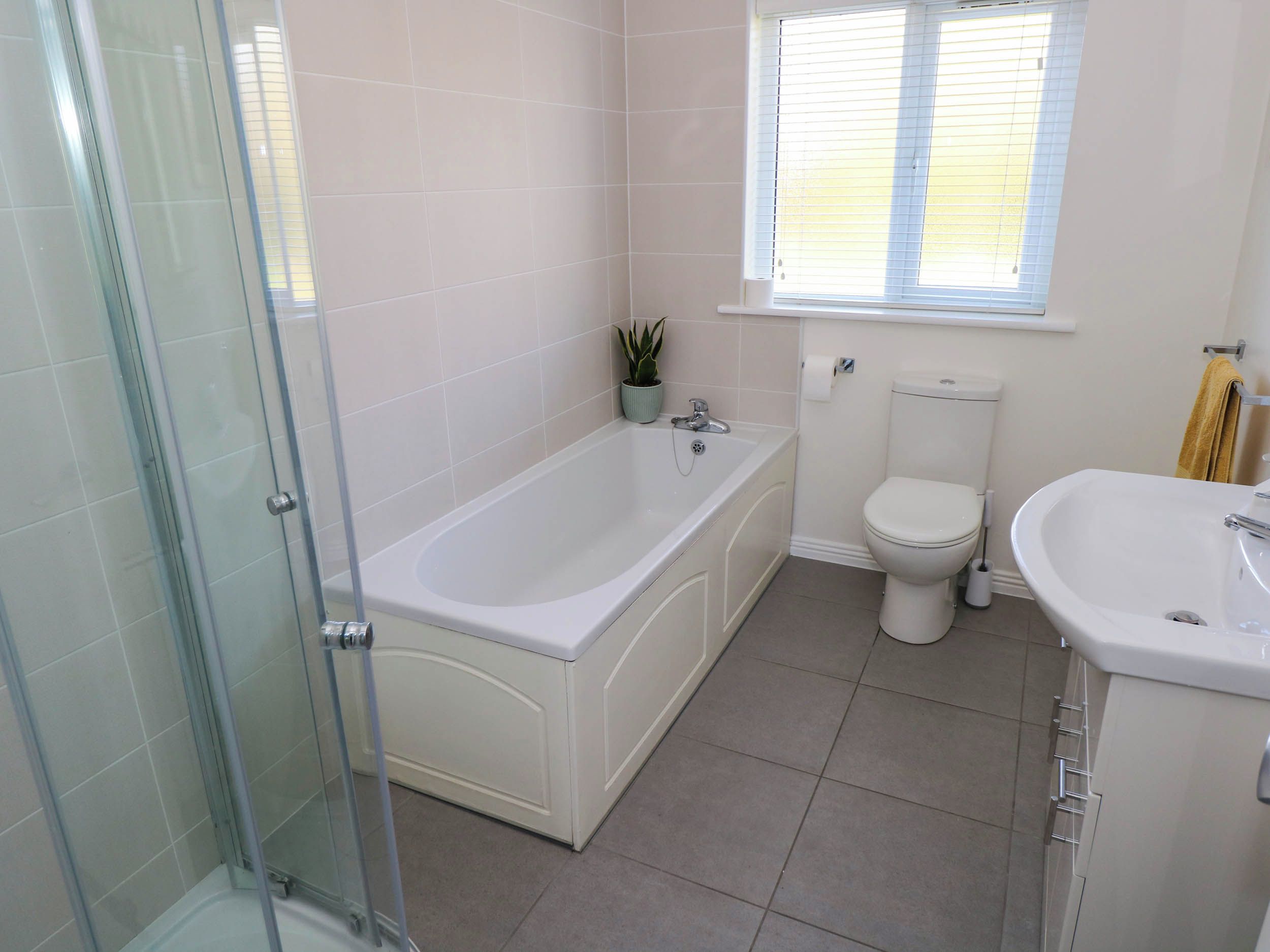Ein Badezimmer mit Duschkabine, Badewanne, Toilette und Waschbecken.