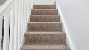 A staircase with a textured carpet and white railings. - Rock Lawn Cottage (Drimoleague)
