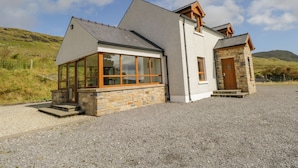 A two-story house with a stone facade, large windows, and a gravel driveway. - Blue Stack House (Letterbarrow)