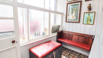 A room with a bench, a vintage trunk, and a patterned floor.