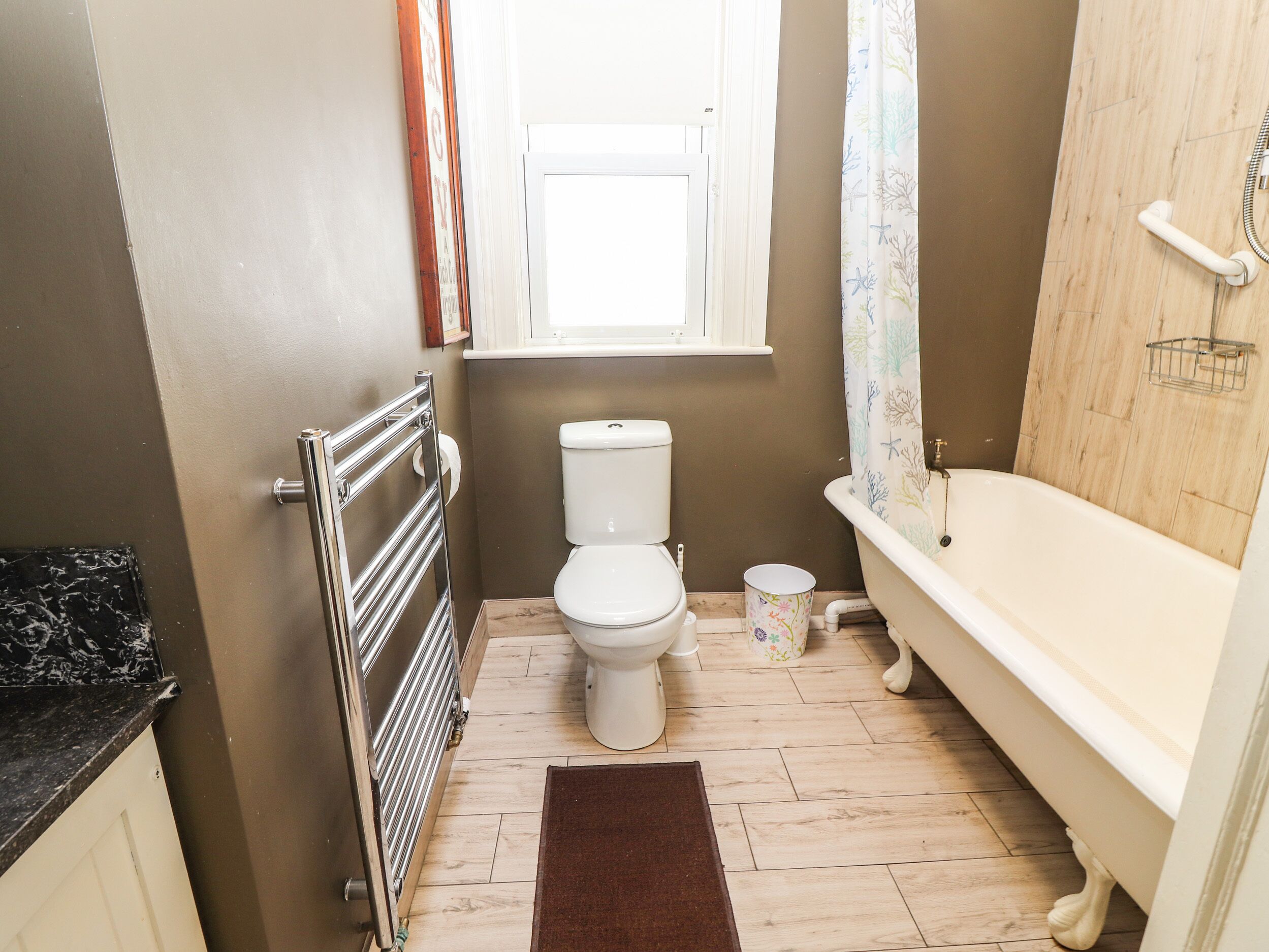 Ein kleines Badezimmer mit Toilette, Badewanne und Heizkörper.