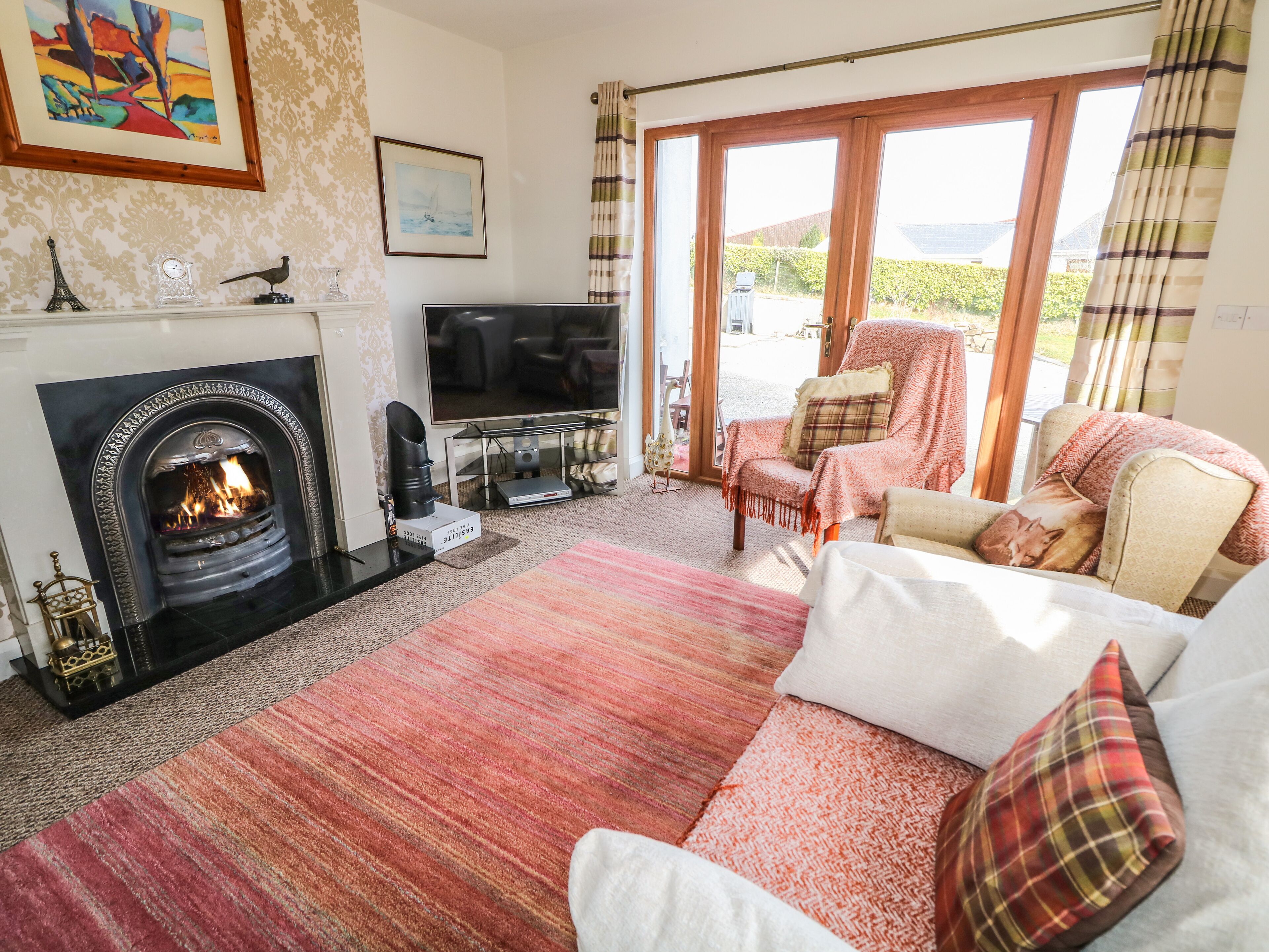 A cozy living room with a fireplace, a flat-screen TV, and comfortable seating.
