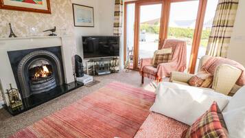 A cozy living room with a fireplace, a flat-screen TV, and comfortable seating.