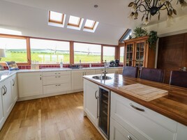 A modern kitchen with a large window, wooden countertop, and a view of the outdoors.