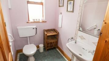 Un baño pequeño con inodoro, lavamanos y ventana.