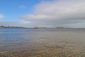 A wide river with clear water and a distant tree line. - Castle View (Carrowmoreknock)