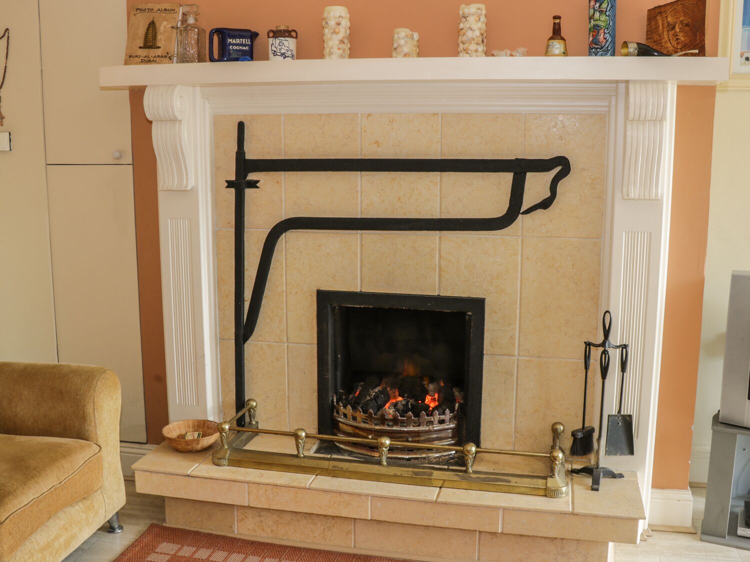 A living room with a fireplace, a sofa, and a mantelpiece with decorative items.