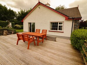 A house with a wooden deck, a dining table, and chairs. - The Lodge (Beaufort)