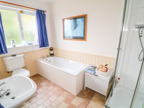 Un baño con inodoro, lavamanos, bañera y ducha.