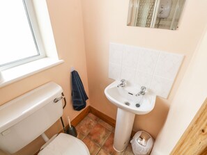 Un baño pequeño con inodoro, lavamanos y ventana.
