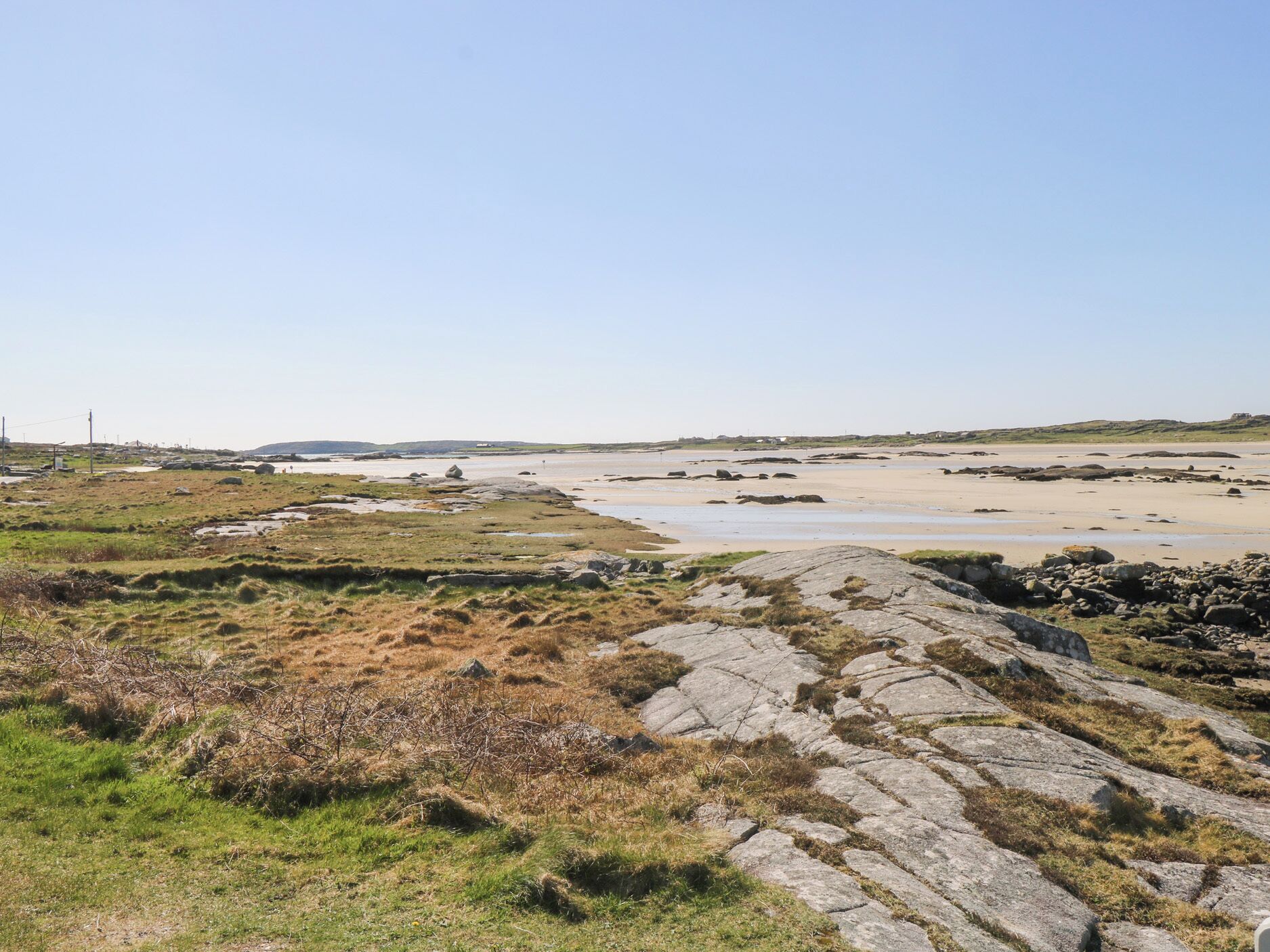 Eine Küstenlandschaft mit felsigem Gelände und einem Sandstrand.