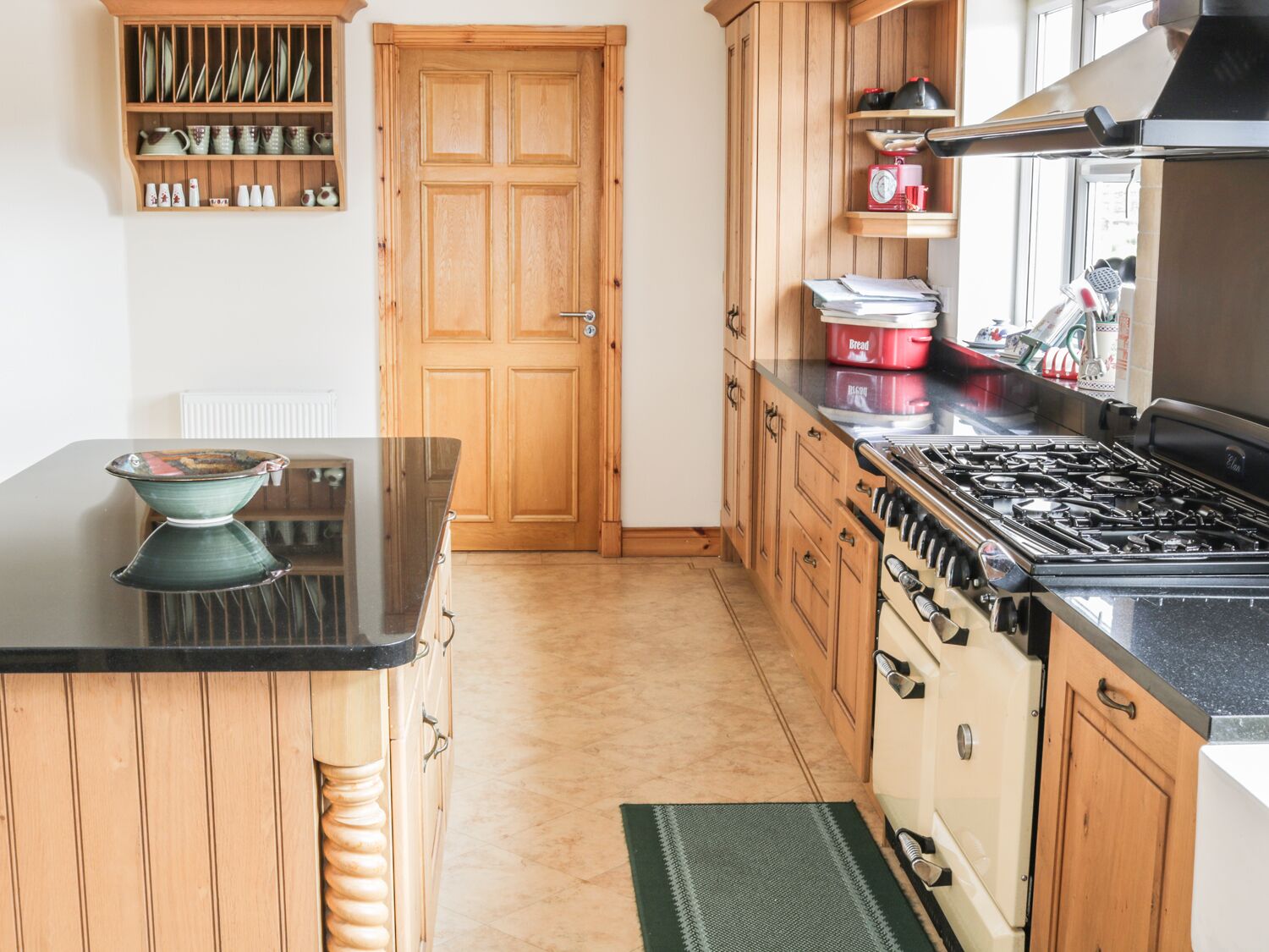 A kitchen with wooden cabinets, a stove, and a countertop with a bowl.