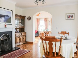 Un comedor con una mesa redonda, sillas de madera y una chimenea.