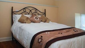 A bed with a headboard, multiple pillows, and a blanket. - Nellie's Farmhouse (Bantry)