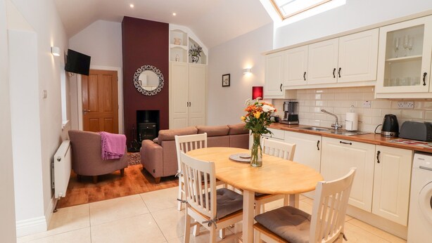 A compact living space with a dining area, kitchen, and seating area. - Laharn Cottage (Killorglin)
