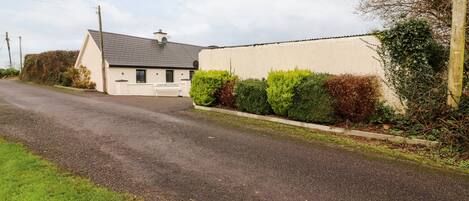 A building labeled "Laharn Cottage" with a gravel driveway and a grassy area in front.