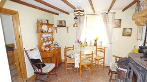 A cozy kitchen with wooden furniture, a tiled floor, and a vintage radio. - Cookies Cottage (Ballyshannon)
