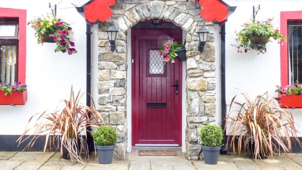 A stone building with a red door, stone walls, and a red roof. - Cookies Cottage (Ballyshannon)