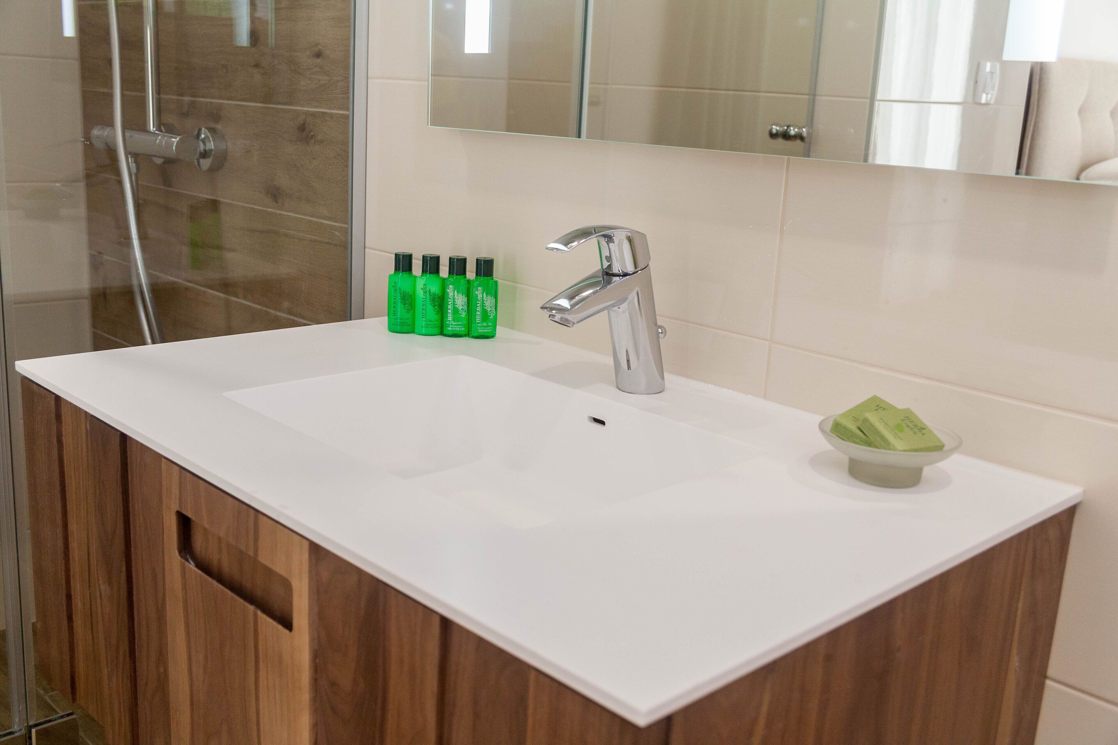 A bathroom with a white sink, a mirror, and a shower.
