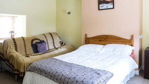 A bedroom with a bed, a sofa, and a wall-mounted picture. - Ferrys (Portsalon)