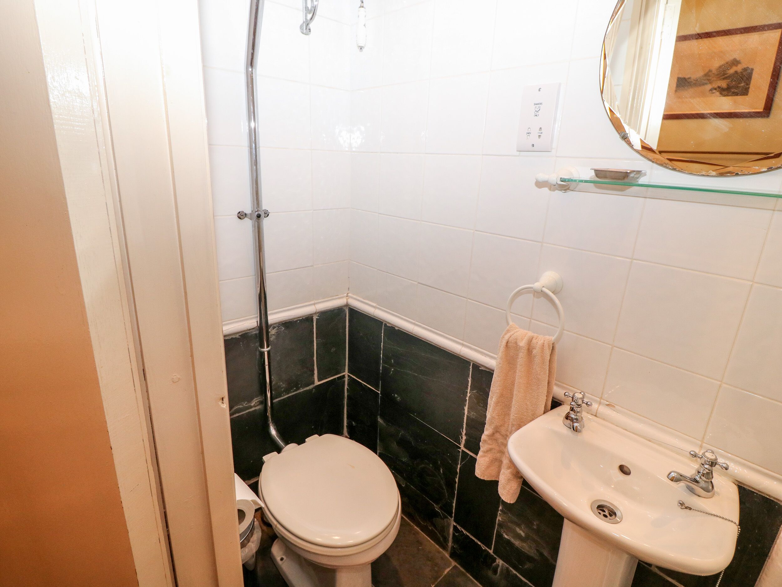 A bathroom with a toilet, sink, and shower.